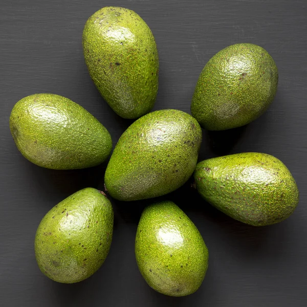 Whole Avocados Black Wooden Surface Top View Overhead — Stock Photo, Image