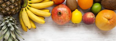 Beyaz ahşap zemin, üstten görünüm üzerinde tropikal meyve kümesi. Düz yatıyordu, ek yükü.