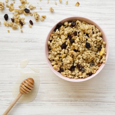 Pembe kase meyve granola ve bal beyaz ahşap zemin, üstten görünüm üzerinde. Üstten, yukarıdaki.