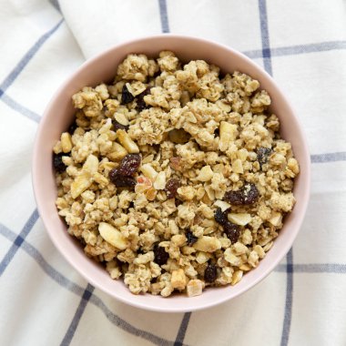 Meyve granola kumaş, üstten görünüm üzerine pembe kase. Yukarıda, ek yükü. Portre.