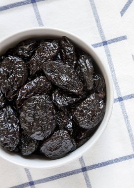 Kumaş, havai görünümü üzerine kuru kuru erik tam kase. Yukarıdan, üstten görünüm düz lay.