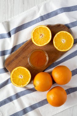 Beyaz ahşap bir masa üstten görünüm üzerinde rustik gemide ev yapımı turuncu marmelade cam kavanoz. Düz, tepegöz, yukarıdan yatıyordu. 