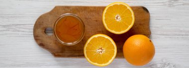 Ev yapımı turuncu marmelade cam beyaz ahşap yüzey, en iyi görünüm üzerinde rustik gemide. Düz, tepegöz, yukarıdan yatıyordu. 