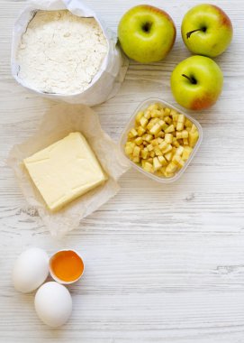 Ham maddeler: elma, un, yumurta, tereyağı elma pasta veya strudel Beyaz ahşap yüzey, en iyi görünümü üzerinde yemek pişirmek için. Düz yatıyordu, ek yükü.