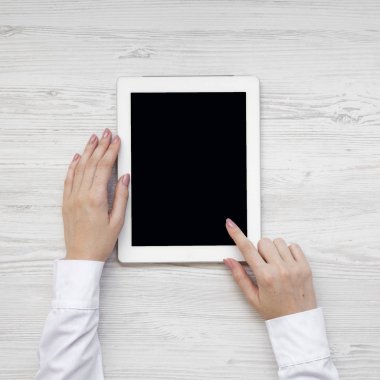 Tablet bir beyaz ahşap masa, havai görünümü kullanarak eller. Yukarıdan, yatıyordu, en iyi görünüm düz.