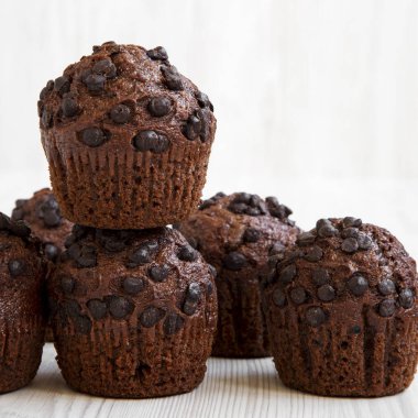 Çikolata muffins Beyaz ahşap masa, yan görünüm üzerinde. Portre. 
