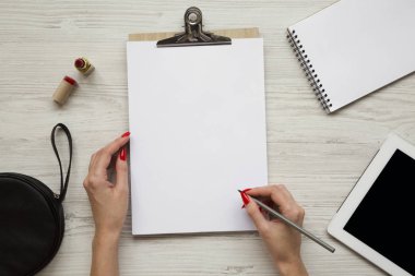 Kalem eller, ruj, tablet, defter ve Pano, üstten görünüm ile kadınsı çalışma alanı. Yukarıdan, ek yük düz lay.