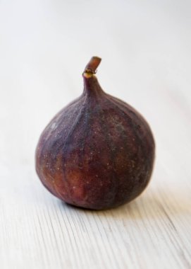 Beyaz ahşap zemin, yan görünüm üzerinde taze incir. Portre.