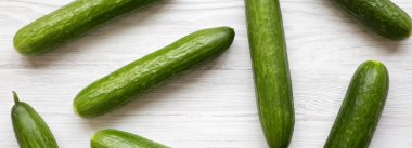 Beyaz ahşap yüzeyine, havai görünümü taze organik yeşil salatalık. Yukarıdan, üstten görünüm düz lay.