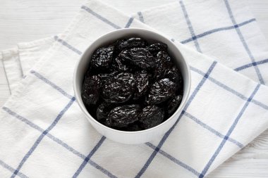 Bir kase kuru erik kuru, görüş açısı düşük. Yakın çekim.