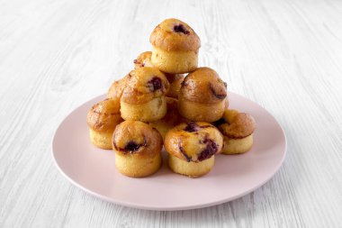 Ev yapımı kek kiraz Beyaz ahşap arka plan, yan görünüm üzerinde pembe plaka ile. Yakın çekim.