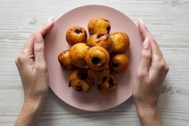 Üstten görünüm, eller pembe plaka mini kekler ile tutun. Yakın çekim. Üstten, yukarıdaki.
