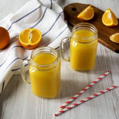 Cam kavanoz, düşük açılı görünümü taze portakal suyu. Portre.