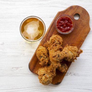 Kızarmış tavuk drumsticks ketçap ve bira, üstten görünüm.