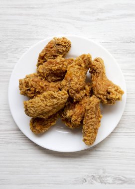 Görünümü en çok, Beyaz ahşap yüzey, en iyi görünümü üzerinde kanatları beyaz yuvarlak tabakta tavuk. Düz yatıyordu, ek yükü. 