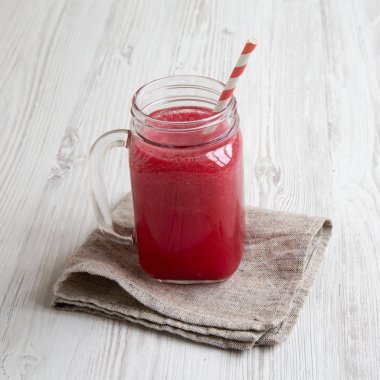 Cam kavanoz karpuz güler yüzlü beyaz ahşap zemin, yan görünüm üzerinde. Yakın çekim.