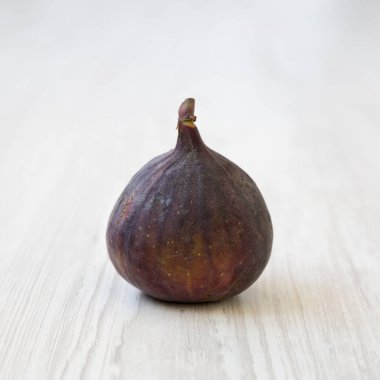 Beyaz ahşap zemin, yan görünüm üzerinde taze incir. Portre.