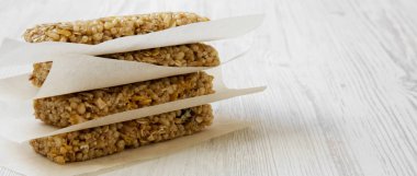 Beyaz ahşap yüzey, yan görünüm üzerinde sac pişirme üzerinde granola barlar. Kopya alanı.