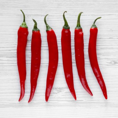 Beyaz ahşap zemin üzerinde sıcak kırmızı pul biber. Yukarıdan, Tepegöz, görünümü top. Portre.