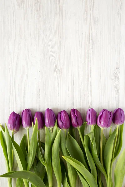 Üstten Görünüm, mor laleler Beyaz ahşap zemin üzerinde. Düz, Tepegöz, yukarıdan yatıyordu. Metin için yer.