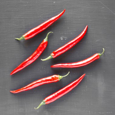 Sıcak kırmızı biber siyah yüzeyi, ek yükü. Yukarıdan, üstten görünüm, düz yatıyordu. Yakın çekim.