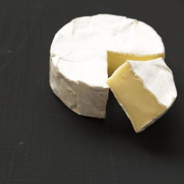 Peynir camembert veya siyah arka plan üzerine brie. Süt üretimi. Yan görünümü. Yakın çekim. 
