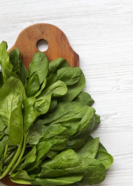 Beyaz ahşap yüzey, en iyi görünümü üzerinde rustik ahşap tahta üzerinde yıkanmış taze ıspanak yaprakları. Yukarıda, ek yükü.