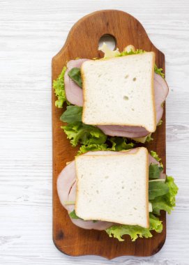 Beyaz ahşap arka plan, üstten görünüm üzerinde bir rustik ahşap tahta üzerinde ev yapımı sandviçler. Üstten, yukarıda. Yemeye hazır.