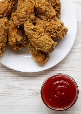 Tavuk kanatları beyaz üzerine ketçap ile yuvarlak beyaz tabakta woo