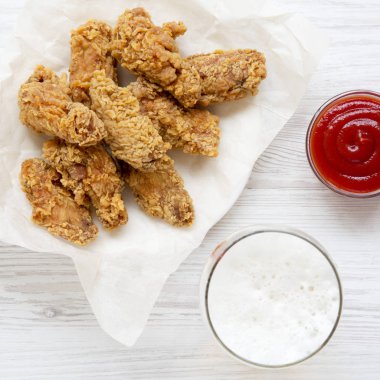 Üst görüntülemek, kızarmış tavuk kanadı ile kırmızı biber sosu, soğuk bir bira, 