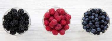 Meyveleri içeren kase: yaban mersini, böğürtlen, ahududu