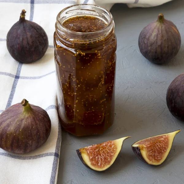 Fig jam em frasco de vidro e figos frescos no fundo de concreto, lado — Fotografia de Stock