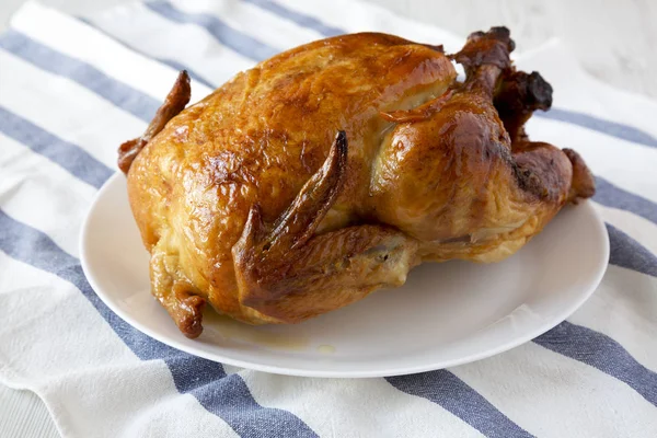 Pollo arrosto fatto in casa su piatto bianco, vista laterale. Primo piano . — Foto Stock