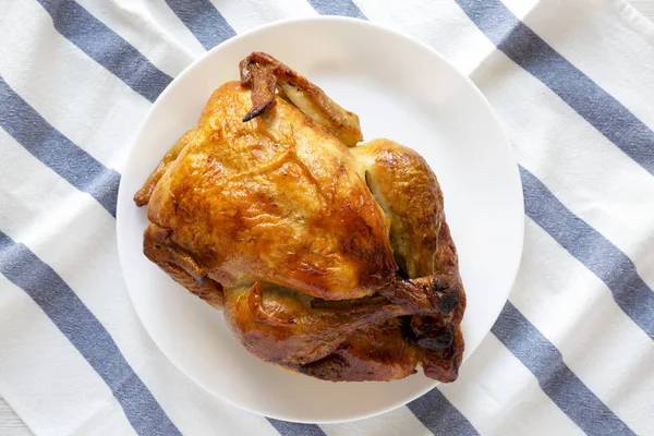 Домашняя вкусная жареная курица на белой тарелке, вид сверху. Плоская квартира — стоковое фото