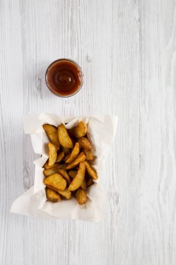 Kızarmış patates dilimleri kağıt kutusu ve Barbekü soslu beyaz w üzerinde