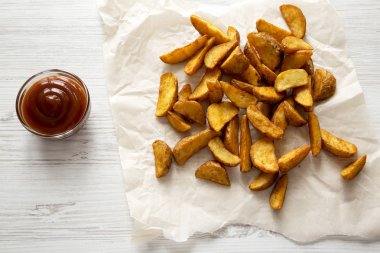 Kızarmış patates dilimleri bir beyaz tahta backgr barbekü sosu ile