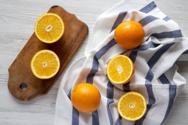 Beyaz ahşap arka planda, üstten görünüm yarıya ve tüm portakal. EY