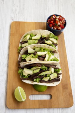 Mısır ekmeği ızgara sığır eti, avokado, kireç ve salsa bam üzerinde