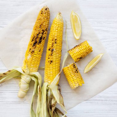 Beyaz ahşap b üzerinde limon dilimleri ile üzerinde ızgara mısır