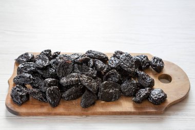 Beyaz ahşap bir masa yan üzerinde rustik ahşap tahta üzerinde kuru kuru erik 