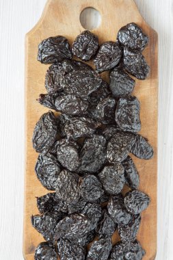 Beyaz ahşap bir masa üst v rustik ahşap tahta üzerinde kuru kuru erik