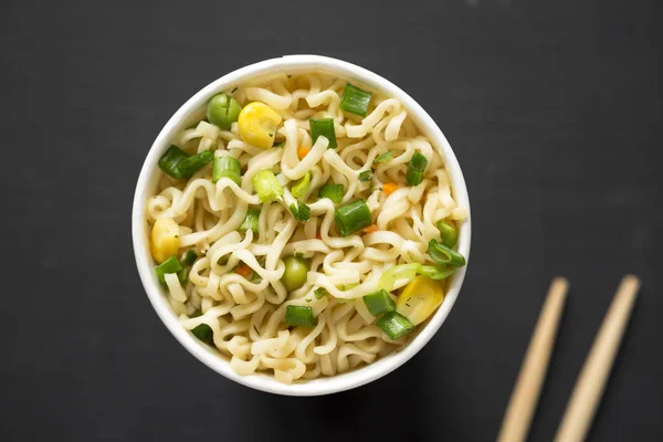 Tasty instant noodles with beef flavoring in a paper cup over bl