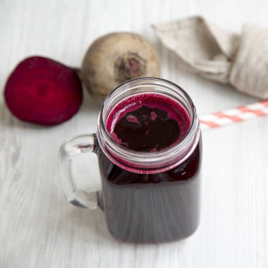 Cam yan v Beyaz ahşap arka plan üzerinde kırmızı pancar suyu