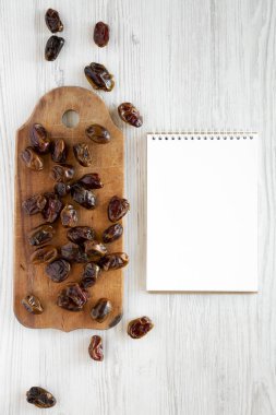 Rustik ahşap tahta, beyaz bitti boş not defteri üzerinde kurutulmuş tarihleri woo