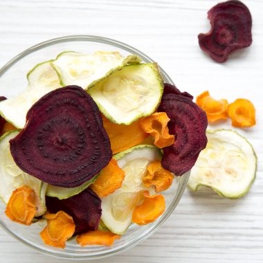 Tam kase sebze cips Beyaz ahşap arka planda, üstten görünüm. 