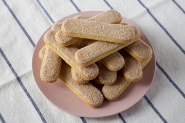 Savoyardi bisküvi pembe plaka, düşük açılı görünümü üzerinde. Yakın çekim.