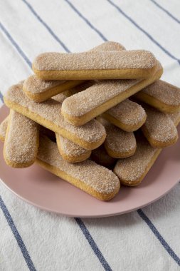 Savoyardi bisküvi pembe plaka, düşük açılı görünümü üzerinde. Yakın çekim.