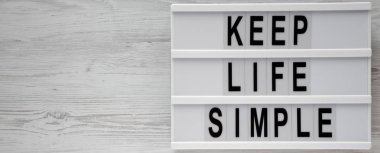 'Hayat basit tutmak' kelimeleri lightbox üzerinde beyaz tahta adam