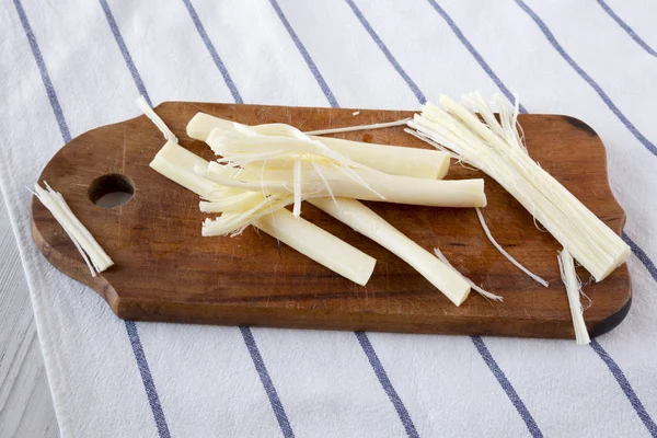 String cheese on rustic wooden board, low angle view. Healthy sn