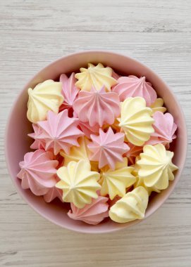 Beyaz ahşap arka plan üzerinde bir pembe Mini meringues kase